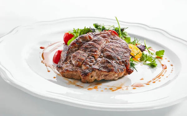 Schweinenackensteak mit gemischtem Salat auf weißem Restaurantteller — Stockfoto