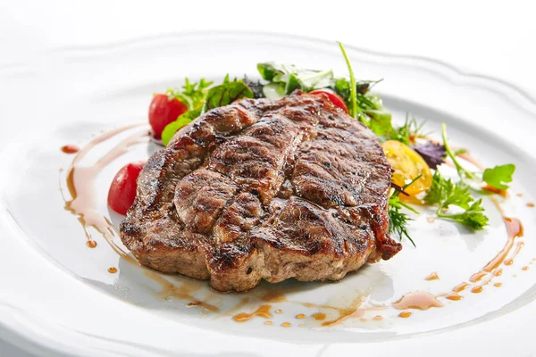 Filete de cuello de cerdo con ensalada mixta en plato de restaurante blanco — Foto de Stock