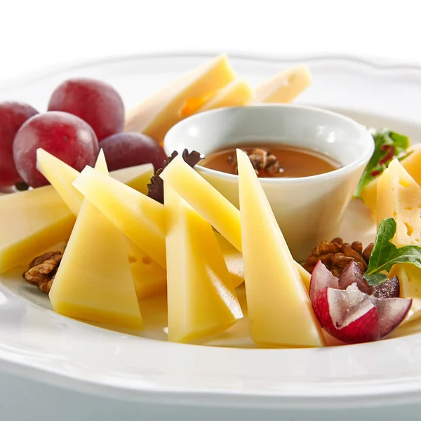 Käseplatte mit Honig, Nüssen und Trauben auf weißem Restaurantboden — Stockfoto