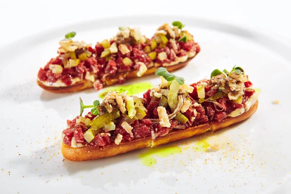 Tartare de carne em torradas com creme de alho preto isolado — Fotografia de Stock