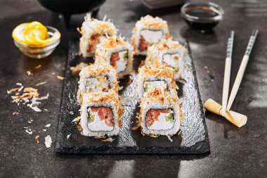 Krem peynir, somon, ton balığı taları veya kurutulmuş bonito, salatalık, nori ile uramaki suşi rulo Makro atış. Japon restoran closeup taze katsuobushi rulo Kısmı
