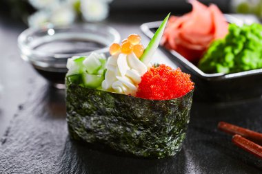 Salatalık ve masago havyar ile lezzetli gunkan. Japon mutfağı restoran menü öğesi. Geleneksel doğu yemeği, ulusal yemek. Lezzetli suşi, ahşap tabak tasnif üzerinde oryantal gıda closeup