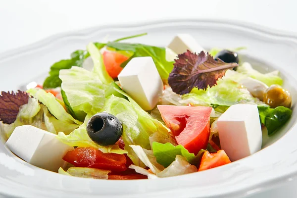 Makroaufnahme von griechischem Salat in hellem Teller isoliert auf weißem Backblech — Stockfoto