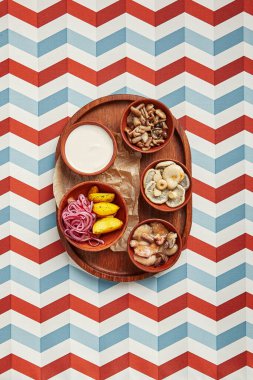 Ahşap tepsi manzaralı abur cubur çeşitleri. Patates ve soğanlı çeşitli mantar turşusu. Kahverengi çömlek kaselerinde restoran aperatifleri servis ettim. Aşçılık sanatı. Yemek porsiyonları. Cafe servisi.