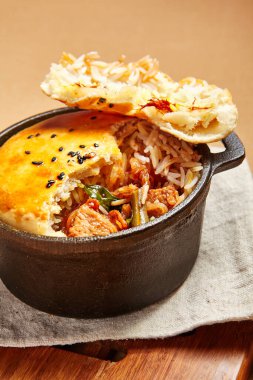 Hamurlu tavuk çorbası. Kümes hayvanları, dökme demir tabakta pirinçle pişiriliyor. Restoran yemeği, yukarıdan servis ediliyor. Güzel yemek bölümü. Et ve sebze dolgulu ekmek. Aşçılık sanatı