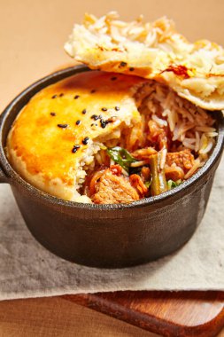 Hamurlu tavuk çorbası. Kümes hayvanları, dökme demir tabakta pirinçle pişiriliyor. Restoran yemeği, yukarıdan servis ediliyor. Güzel yemek bölümü. Et ve sebze dolgulu ekmek. Aşçılık sanatı