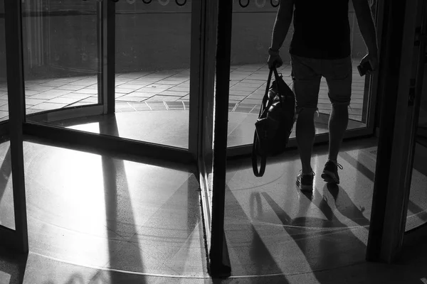 Man walking in revolving door at buss station.