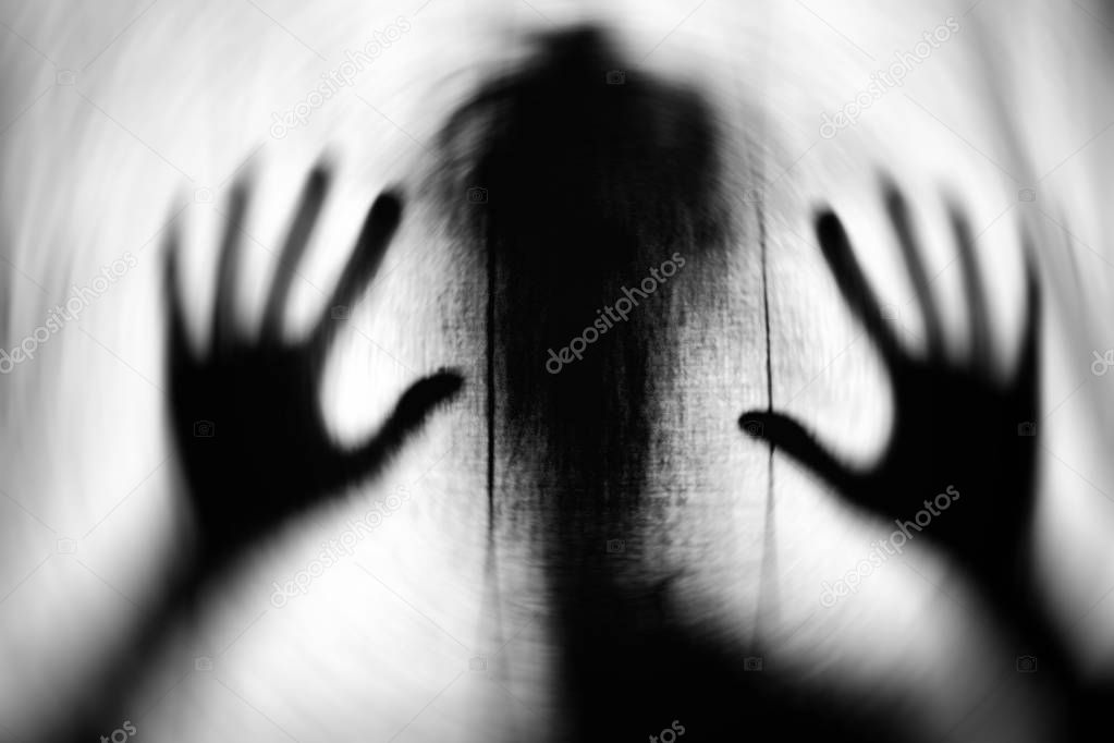 Textured image in motion blur of scary ghost as a silhouette with big hands.