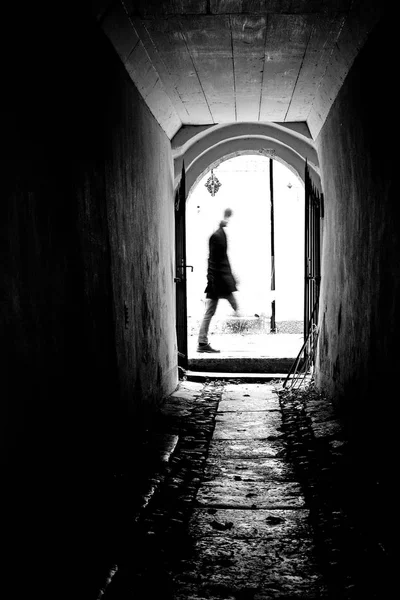 Silhouette der Bewegung blauer Mann am Ende des antiken Tunnels. — Stockfoto