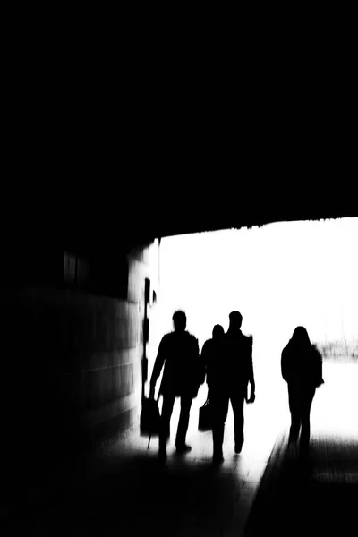 トンネルを歩く若者のグループの創造的な暗いイメージ — ストック写真