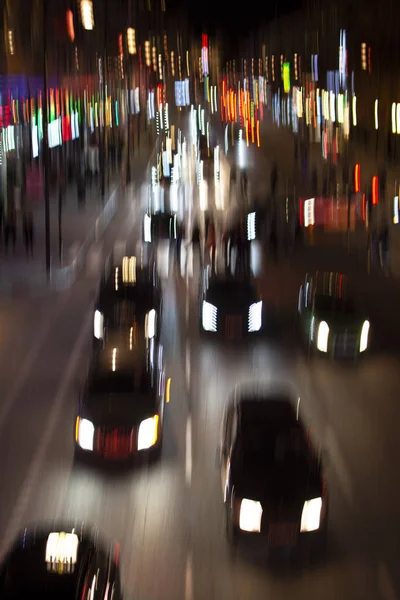 Cars in motion blur at busy city street in the night with streaks of light.