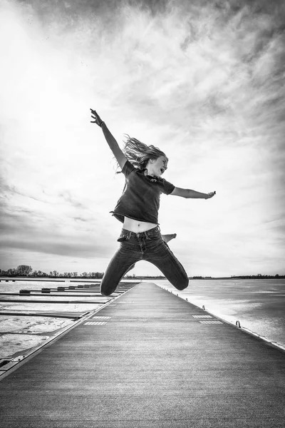 Текстурированное Изображение Счастливой Молодой Девушки Прыгающей Высоко Воздух Деревянном Причале — стоковое фото
