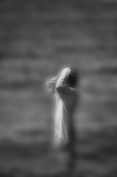 超现实模糊的黑白形象的无法辨认的女人站在水中 — 图库照片