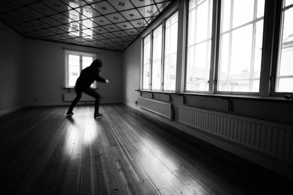 Suspicious silhouette moving in empty room with many windows. — Stock Photo, Image