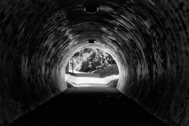 Sonunda park olan karanlık, kirli bir tünel.