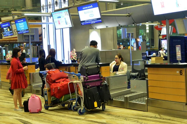 Singapur-Mayıs 18, 2018: İnsanlar sıra Singapur Changi Havaalanı'nda. Changi Havaalanı Güneydoğu Asya'nın en büyük ulaşım merkezleri biridir