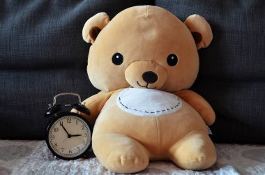 Brown cute teddy bear hold alarm clock clipart