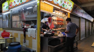 Singapur-27 Aralık, 2018: İnsanlar Singapur hawker Center'da gıdalar satın. Çoğu Singaporeans günde en az bir kez yemek bu yüzden ucuz gıda tezgahları şehirde çoktur.