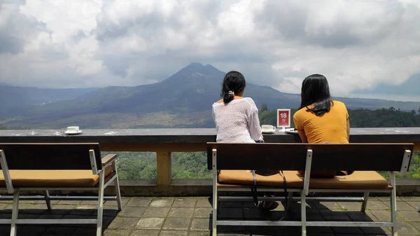 Jovens mulheres apreciam o café com fundo do Monte Batur volc — Fotografia de Stock