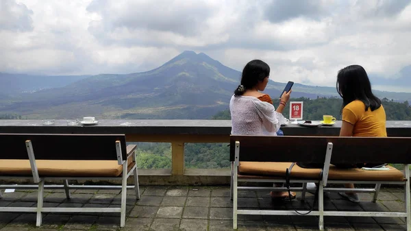 Молодые женщины наслаждаются кофе на фоне горы Батур Вольц — стоковое фото
