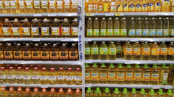 Estantes de supermercado con botellas de aceites de cocina en un mercado i — Foto de Stock