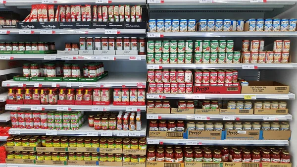 Variedad de alimentos de lata exhiben en rack para vender en el supermercado —  Fotos de Stock