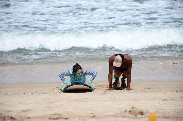 Lidé se učí surfování na balijské pláži — Stock fotografie