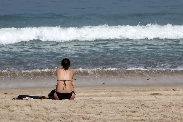 Vista posterior de la mujer sexy en bikini sentado en arena blanca tropical — Foto de Stock