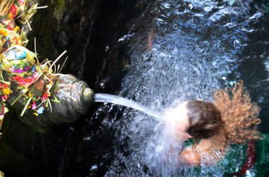 Bali Tirta Empul tapınağında suda tapanların dua,