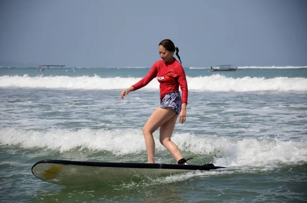 Giro dei giovani surfisti sulla tavola da surf con divertimento sulle onde del mare nell'isola di Bali — Foto Stock