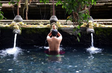 Pura Tirta Empul 'daki kutsal havuzun kutsal kaynak suyunda dua ediyorum. 