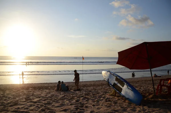 La gente disfruta de la dramática puesta de sol en la playa de Kuta, Bali — Foto de Stock