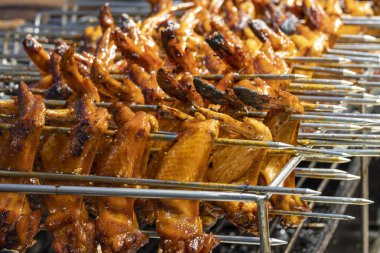 Barbekü tavuk kanadı gece pazarında satılıyor.