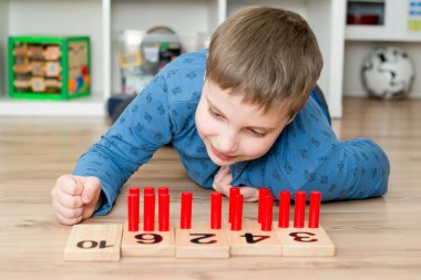 Çocuk yerde yatıyor ve sayma oyunu oynuyor 