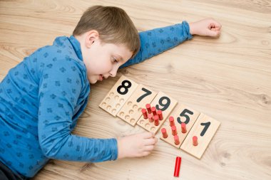 Çocuk yerde yatıyor ve sayma oyunu oynuyor 