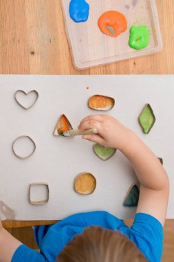 Çocuk geometrik şekilleri öğreniyor. Güzel motor beceriler. Anaokulu ya da özel görevler. Çocukların erken eğitimi. Montessori yöntembilimi.