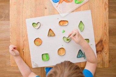 Çocuk geometrik şekilleri öğreniyor. Güzel motor beceriler. Anaokulu ya da özel görevler. Çocukların erken eğitimi. Montessori yöntembilimi.