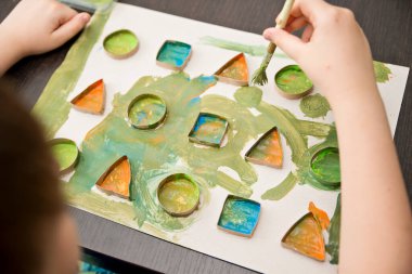 Çocuk geometrik şekilleri öğreniyor. Güzel motor beceriler. Anaokulu ya da özel görevler. Çocukların erken eğitimi. Montessori yöntembilimi.