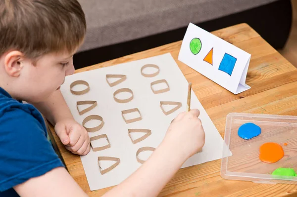 Çocuk geometrik şekilleri öğreniyor. Güzel motor beceriler. Anaokulu ya da özel görevler. Çocukların erken eğitimi. Montessori yöntembilimi.