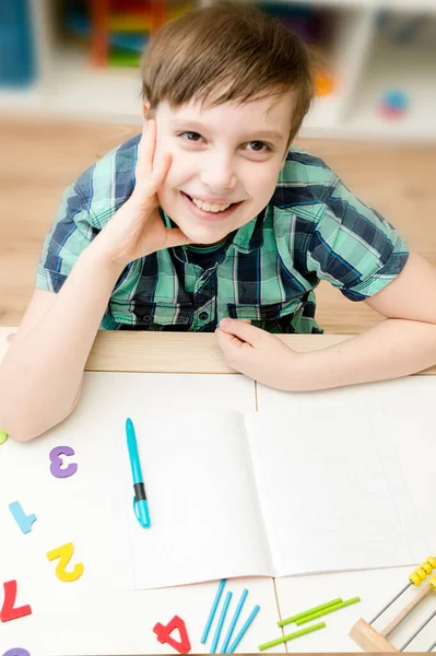 Young school boy studying at home. Boy doing homework in study room. Back to school.