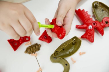 Plastik parçalardan yapılmış dinozor üreticisi. Güzel motor beceriler. Anaokulu ya da özel görevler. Çocukların erken eğitimi. Montessori yöntembilimi.