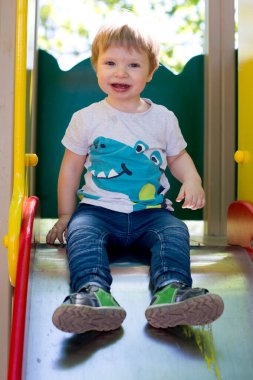 Çocuk parkında 2 yaşında bir çocuk. Bahçede bir yaz günü. Basketbol ustası olmanın yolu bu..