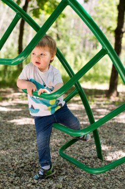 Çocuk parkında 2 yaşında bir çocuk. Bahçede bir yaz günü. Basketbol ustası olmanın yolu bu..