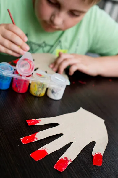 Play at home. kid on paper hand applying painting. manicure salon. educational creative lesson.