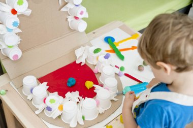 Küçük bir çocuk dişçiyi oynuyor. Montessori kumaşı. Sahte çene ve diş fırçası. Oyun yoluyla eğitim.