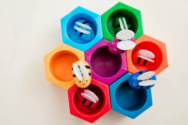 Cımbızlı bebekler için oyuncaklar. Renkli arı kovanı. Bal peteğindeki arılar. Parlak gökkuşağı renkli. Küçükler için okul öncesi oyunu. Montessori eğitimi.