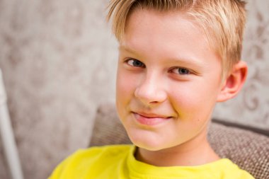 Yaramazlık, sinsi bir bakış. Genç çocuk gizemli bir gülümsemeyle kameraya bakar.