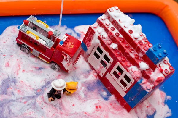 불장난감 플라스틱 하우스에 거품과 페인트 뿌리는 소방차를 — 스톡 사진