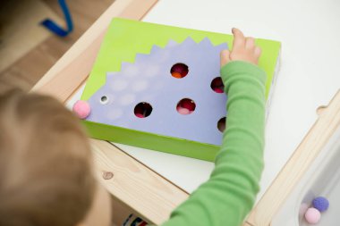 Kirpi. Küçük çocuklar için oyun düzenleme. Çukurları ponponlarla doldurun. Erken eğitim, renk öğrenme ve sayısallık. Montessori anaokulu ve özel ihtiyaçlar okulu için temalı uygulama