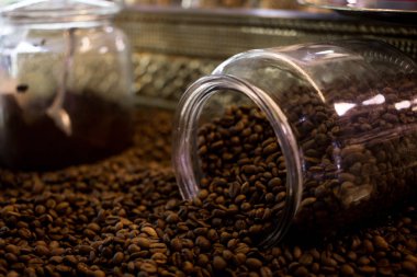 Kavrulmuş kahve çekirdekleri şeffaf cam kavanoz dağınık çok yakın çekim